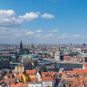 A panoramic view of Berlin skyline with historic and modern buildings under a partly cloudy sky.